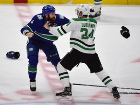 Canucks defenceman Jordie Benn (4) fights with Dallas Stars forward Roope Hintz (24) during the first period at Rogers Arena.