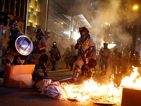 Police passes a burning barricade to break up thousands of anti-government protesters during a march billed as a global "emergency call" for autonomy, in Hong Kong, China Nov. 2, 2019.