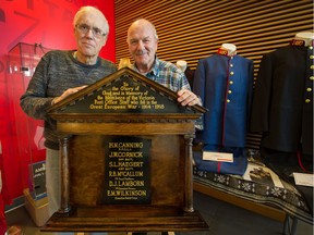 Jim Bain, left, and Fred Danells, with a plaque dedicated to six war-dead postal workers 100 years ago, at the Canada Post processing facility in Richmond on Nov. 6.