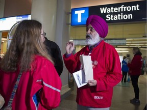 Unifor member Rajinder Purewal talks with a transit user during a picket at Waterfront Station in Vancouver to hand out information about the transit dispute.