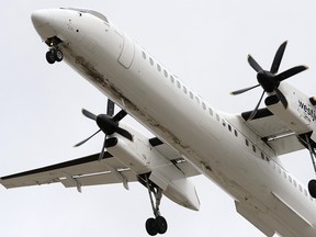 A WestJet Encore De Havilland Canada DHC-8-400 aircraft landing at Edmonton International Airport.