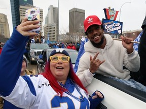 Winnipeg Blue Bombers' fan Samantha Houzon takes her picture with defensive back Marcus Sayles during Tuesday's Grey Cup parade in Winnipeg.