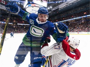 Tanner Pearson runs over Brett Kulak of the Montreal Canadiens along the end boards during NHL action at Rogers Arena on Dec. 17, 2019 in Vancouver.
