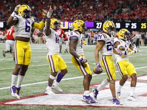 Derek Stingley Jr. (clutching the football) and Louisiana State University teammates celebrate his third-quarter interception during the LSU Tigers’ 37-10 win over the University of Georgia Bulldogs in the SEC Championship game in Atlanta, Ga., on Dec. 7, 2019.