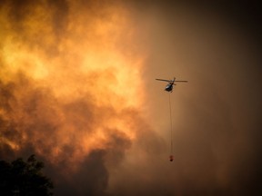 Helicopters dump water on bushfires as they approach homes located on the outskirts of the town of Bargo on December 21, 2019 in Sydney, Australia. A catastrophic fire danger warning has been issued for the greater Sydney region, the Illawarra and southern ranges as hot, windy conditions continue to hamper firefighting efforts across NSW. NSW Premier Gladys Berejiklian declared a state of emergency on Thursday, the second state of emergency declared in NSW since the start of the bushfire season.