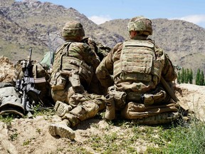 In this file photo taken on June 6, 2019, U.S. soldiers look out over hillsides during a visit of the commander of U.S. and NATO forces in Afghanistan General Scott Miller at the Afghan National Army (ANA) checkpoint in Nerkh district of Wardak province.