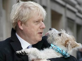 Prime Minister Boris Johnson poses outside Methodist Hall polling station as he casts his vote with dog Dilyn, on December 12, 2019 in London, England.