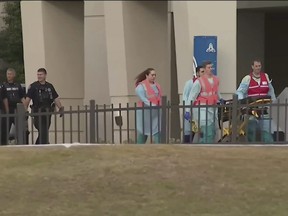 This photo taken from video provided by WEAR-TV shows emergency responders near the Naval Air Base Station in Pensacola, Fla., Friday, Dec. 6, 2019. The US Navy is confirming that an active shooter and one other person are dead after gunfire at the Naval Air Station in Pensacola. Area hospital representatives tell The Associated Press that at least 11 people were hospitalized. The base remains locked down amid a huge law enforcement response.  (WEAR-TV via AP)