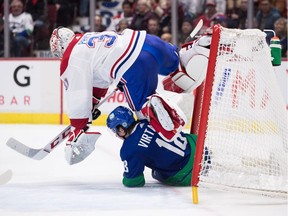 Jake Virtanen, bottom, crashes into Montreal Canadiens goalie Carey Price during the second period.