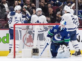 Toronto Maple Leafs' John Tavares, front left, Auston Matthews, back left, Alexander Kerfoot, Justin Holl (3) and Travis Dermott (23) celebrate Matthews' goal against Vancouver Canucks goalie Jacob Markstrom (25) during the second period of an NHL hockey game in Vancouver, on Tuesday December 10, 2019. ORG XMIT: VCRD211 [PNG Merlin Archive]