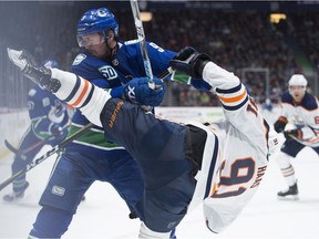 Vancouver Canucks centre J.T. Miller (9) fights for control of the puck with Edmonton Oilers centre Gaetan Haas (91) during second period action.