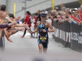 Angela Naeth, from Prince George, British Columbia, nears the tape to be the first women finisher in Ironman Chattanooga on Sunday, Sept. 28, 2014, in Chattanooga, Tenn.