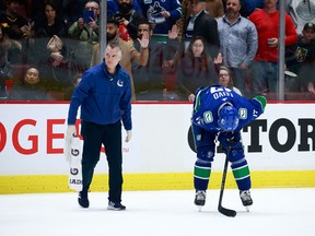 Canucks athletic therapist Jon Sanderson tends to an injured Josh Leivo during the Dec. 19 game against the Vegas Golden Knights in Vancouver.