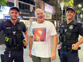 Shawn McCormick, wearing an "I am not Scott Morrison" shirt poses with police officers during a recent trip to Australia.