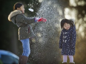In this 2017 file photo, Ha-Yeon Bahng showers her sister Ha-Eum in frosty snow, near Ferguson Point in Vancouver's Stanley Park.