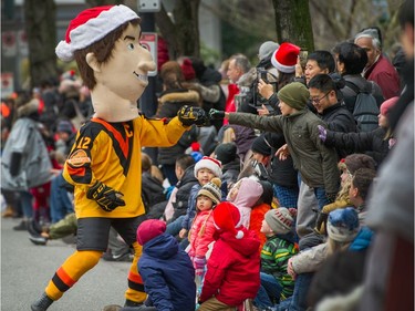 Stan Smyl fist-pumps an onlooker during the Santa Claus Parade in Vancouver,
