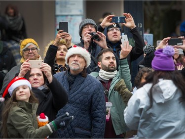 People record images and video during the Santa Claus Parade