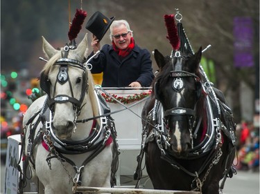 Gerry O'Neil tips his hat from his horse drawn carriage during Santa Claus Parade in Vancouver.