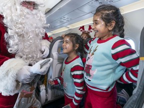 Kalyssa and Kiyana (right) get a visit from Santa Claus aboard the Air Transat/Children's Wish Foundation Santa Claus Flight on Wednesday. It was the 15th annual ‘Flight with Santa Claus,’ when hundreds of children coping with severe illnesses and their families boarded a flight out of Vancouver to meet Santa and his elves up high in the sky.