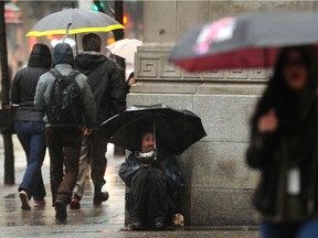 Pedestrians brave the heavy rain during a severe rain warning in Vancouver in December 2018. Environment Canada says residents on the central coast and west Vancouver Island could get more than 100 millimetres of rain before the end of Tuesday.