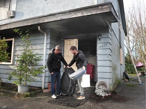 Marcos Nevu (RIGHT) removes belongings after a fire destroyed a fourplex at 10877 133A Street, in Surrey on Sunday morning.