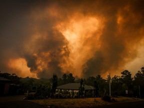 Two bushfires approach a home located on the outskirts of the town of Bargo, near Sydney, Australia, on Dec. 21, 2019.