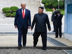 In this file photo taken on June 30, 2019 North Korea's leader Kim Jong Un and US President Donald Trump cross south of the Military Demarcation Line that divides North and South Korea, after Trump briefly stepped over to the northern side, in the Joint Security Area (JSA) of Panmunjom in the Demilitarized zone (DMZ).