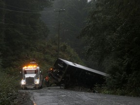 A police crash reconstruction says a bus loaded with University of Victoria students moved over for an oncoming vehicle just as a logging road narrowed before the rollover that killed two students. A tow-truck crew removes a bus from an embankment next to a logging road near Bamfield, B.C., Saturday, Sept. 14, 2019.