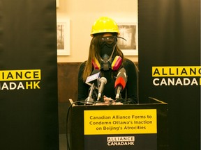 Cherie Wong of Alliance Canada Hong Kong speaks at a news conference on China's human-rights record at the Sandman Hotel in Downtown Vancouver on Jan. 21 wearing equipment demonstrators in Hong Kong are using to protect themselves from police.