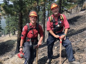 Father and son wildfire fighters Jeff Austin, right, and Vince, left, carrying drip torch, on the fire line outside Penticton in 2008.