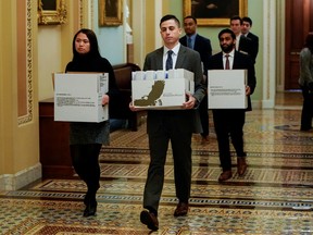 Staffers carry boxes of documents to Senate Minority Leader Chuck Schumer's (D-NY) office on the first day of the impeachment trial of U.S. President Donald Trump on Capitol Hill in Washington, U.S., January 21, 2020.