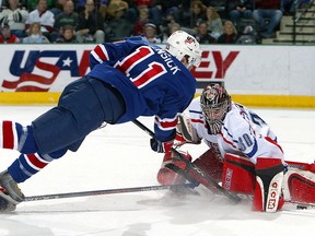 Tim Hensick of Team USA is sent flying through the air after being tripped up, and goalie Marek Schwarz of Team Czech Republic makes a save during the bronze medal game at the World Jr. Hockey tournament on January 4, 2005 at the Ralph Englestad Arena in Grand Forks, North Dakota.