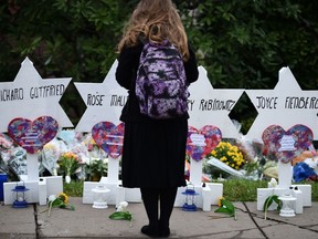 A woman stands at a memorial outside the Tree of Life synagogue after a shooting there left 11 people dead in the Squirrel Hill neighbourhood of Pittsburgh on Oct. 27, 2018.