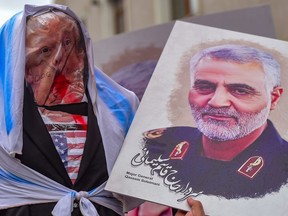 Protesters hold an effigy of US President Donald Trump and a picture of Iranian commander Qasem Soleimani, during a demonstration outside the US consulate in Istanbul, on Jan. 5, 2020.