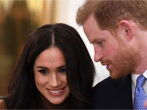 In this file photo taken on January 07, 2020 Britain's Prince Harry, Duke of Sussex and Meghan, Duchess of Sussex react during their visit to Canada House in thanks for the warm Canadian hospitality and support they received during their recent stay in Canada,  in London. - Britain's Prince Harry and his wife Meghan will give up their titles and stop receiving public funds following their decision to give up front-line royal duties, Buckingham Palace said on January 18, 2020. "The Sussexes will not use their HRH titles as they are no longer working members of the Royal Family," the Palace said, adding that the couple have agreed to repay some past expenses. (Photo by DANIEL LEAL-OLIVAS / various sources / AFP)