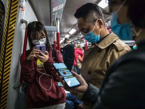 People wear masks while commuting on a train in Hong Kong on Jan. 26, 2020, as a preventative measure following a coronavirus outbreak which began in the Chinese city of Wuhan.