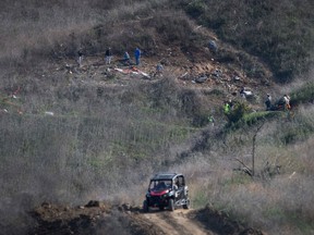 Investigators work at the scene of a helicopter crash in Calabasas, Calif., on Monday, Jan. 27, 2020 that killed nine people included former Los Angeles Laker star and NBA legend Kobe Bryant and his daughter Gianna Maria.