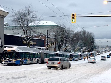 A fleet of southbound TransLink buses are stuck at the bottom of Granville Street during Wednesday's snowstorm in Vancouver.
