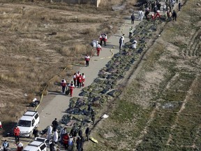 Bodies of the victims of a Ukrainian plane crash are collected by rescue team at the scene of the crash in Shahedshahr, southwest of the capital Tehran, Iran, Wednesday, Jan. 8, 2020. Canada's national police force is taking part in the massive effort to identify dozens of Canadians killed in last week's plane crash in Iran.