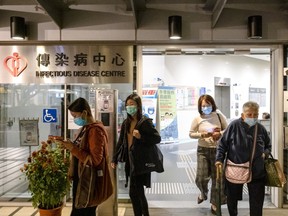 People wearing face masks exit the Infectious Disease Centre at Princess Margaret Hospital in Hong Kong, China, on Wednesday, Jan. 22, 2020. China ramped up efforts to contain a new respiratory virus that's killed nine people and infected hundreds, as the outbreak spread to Asia's financial capital with the first reported case of the deadly illness in Hong Kong.
