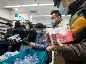 People wait in line to purchase protective masks at a Watsons store in Hong Kong on Wednesday, Jan. 29, 2020.