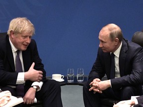 British Prime Minister Boris Johnson (left) talks with Russia President Vladimir Putin during the Libya summit in Berlin, Germany, on Jan. 19, 2020.