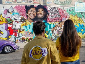 Los Angeles Lakers fans gather around a mural in Los Angeles this week to pay respects to Kobe Bryant after a helicopter crash killed the retired basketball star last weekend.