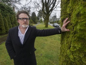 University Endowment Lands homeowner Chris Wall stands beside one of the maple trees near his house on Wesbrook Crescent in January, 2020, not long after the decision to remove 15 a year was announced.