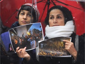 Members of the Iranian community gather for a vigil at the Vancouver Art Gallery on Sunday.