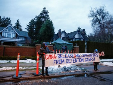 Protesters hold a large sign against China's Uighur camps, labeled as vocational training centres by the Chinese government, outside the home of Huawei Chief Financial Officer Meng Wanzhou before her extradition hearing at B.C. Supreme Court in Vancouver, British Columbia, Canada January 20, 2020.  REUTERS/Lindsey Wasson
