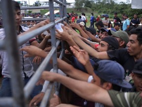 Migrants from Central America, part of a caravan travelling to the U.S., grab water as they wait to cross into Mexico at the border between Guatemala and Mexico, in El Ceibo, Guatemala, January 18, 2020.