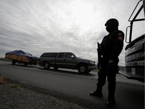 A state police officer keeps watch at a highway during the "12th Caravan of Migrants" in Escobedo, state of Nuevo Leon, Mexico December 17, 2019. About 1,500 families departed from the Texan border city of Laredo in a yearly caravan made up of Mexican migrants and Americans of Mexican origin to return to Mexico for their Christmas holidays, driving cars laden with new clothes, perfumes and other Christmas presents. Picture taken December 17, 2019.