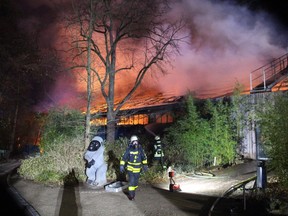 Firemen work at the burning monkey house of the zoo in Krefeld, western Germany, on early January 1, 2020. - Fire ripped through the monkey house at Krefeld zoo on New Year's Eve, killing dozens of animals, including orangutans, chimpanzees and marmosets, the management said.