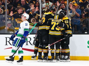 Troy Stecher skates away after the Bruins celebrate scoring the game's opening goal.